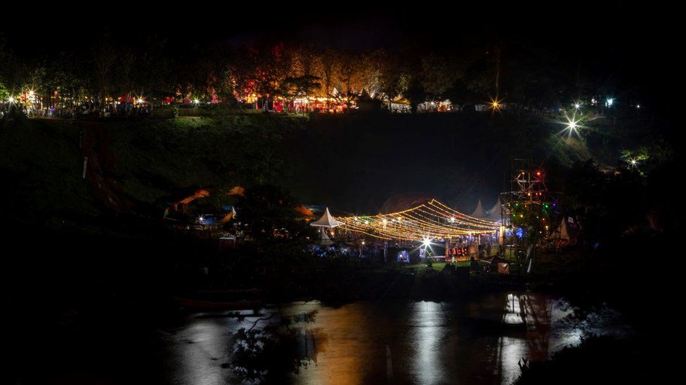 This photograph taken on September 16, 2022, shows a view of the Ugandan Nyege Nyege festival and its lights from the stage reflecting in river Nile at the Itanda Falls on the second day of Nyege Nyege festival, the annual four-day international music festival, in Jinja, Uganda.