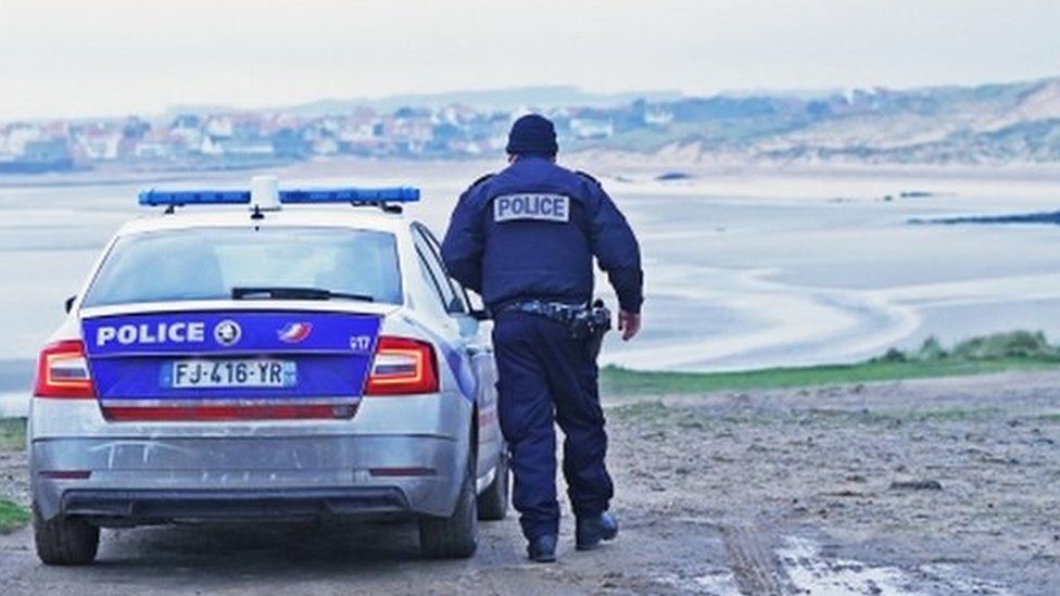 Lone French police officer overlooking the local coastline, a beach in Wimereux, France, 25 Nov 2021