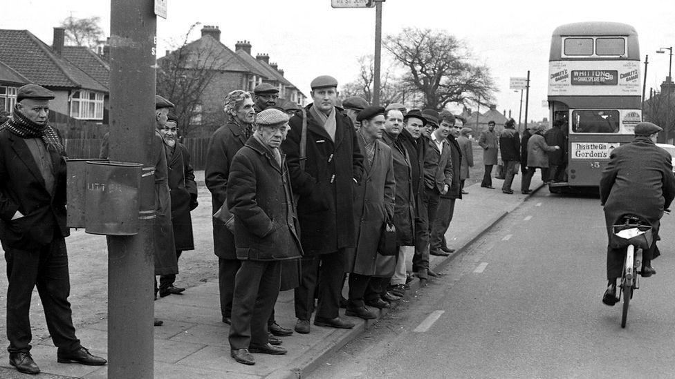 Factory workers at a bus stop in Ipswich