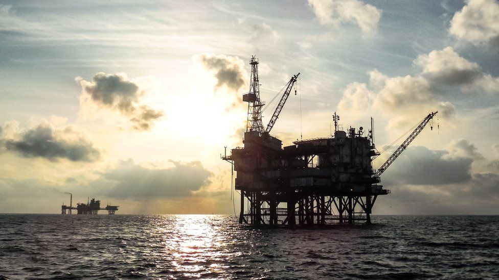 Offshore oil platform at sunset. - stock photo
