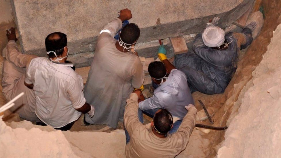 A photo from the Egyptian Ministry of Antiquities shows workers preparing to open the black granite sarcophagus