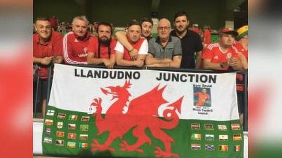 Brad Evans and fellow Wales fans from Llandudno Junction with the flag that's travelled to every Wales match