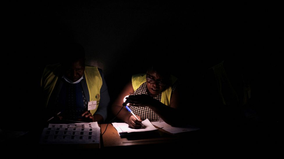 The Zimbabwe Electoral Commission (ZEC) officers process a voter's details during the general election, at a polling station in Luveve township in Bulawayo, Zimbabwe.