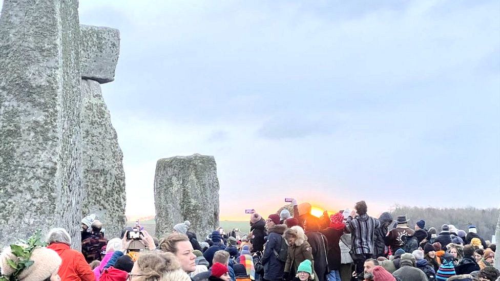 Crowds watching the sun rise at Stonehenge