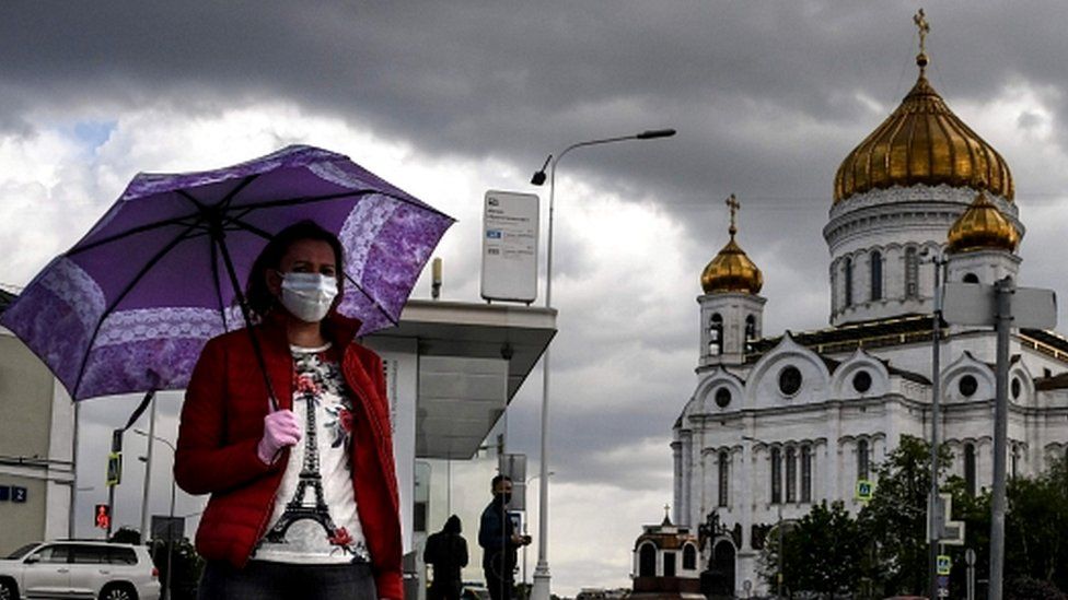 A woman walks past Christ the Savior cathedral in central Moscow on May 14, 2020