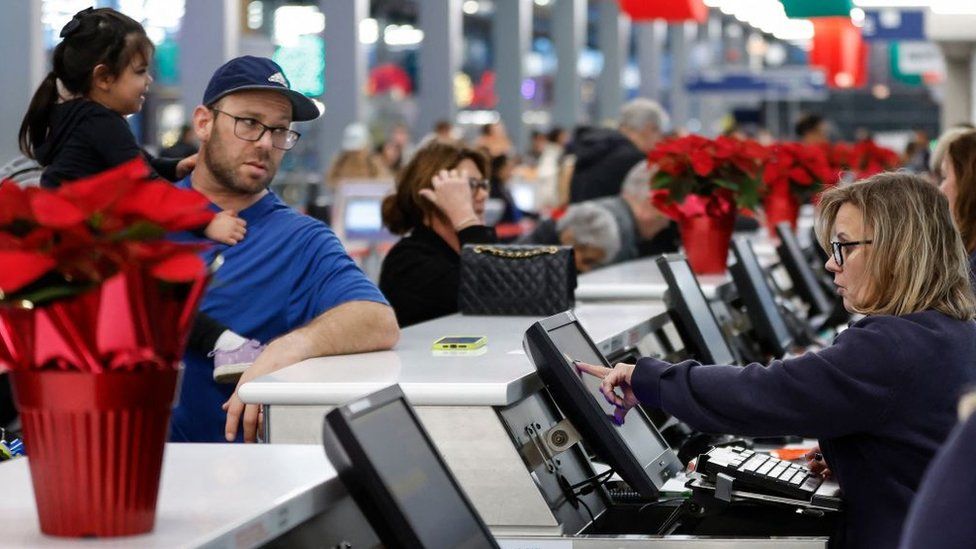 An airline agent helps travellers at O'Hare International Airport Terminal 1 in Chicago, Illinois, on November 21, 2023, ahead of last year's Thanksgiving holiday