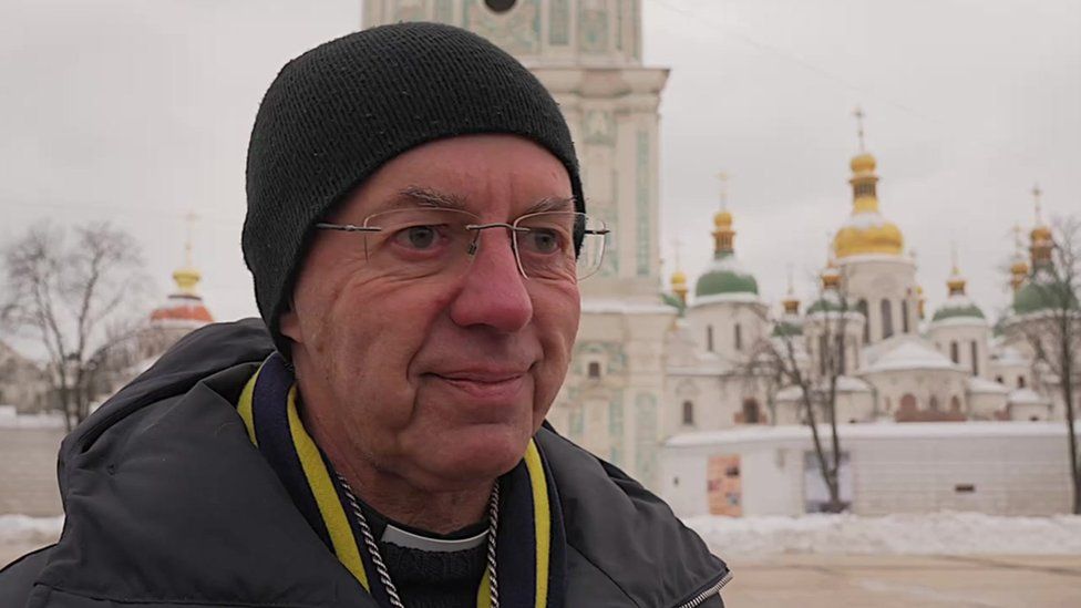 The Archbishop of Canterbury in Ukraine's capital in front of ornate buildings.