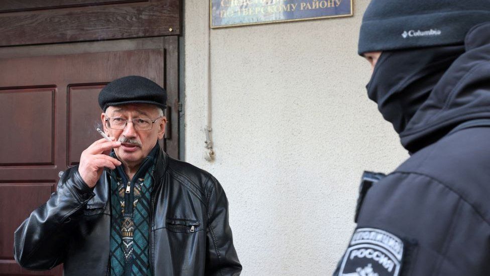 Oleg Orlov, co-chair of the Memorial rights group, smoking a cigarette as he is taken to the Russian Investigative Committee in Moscow