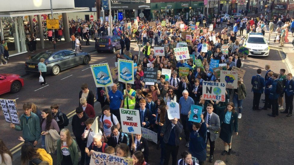 Protesters march at the climate change demonstration in Belfast