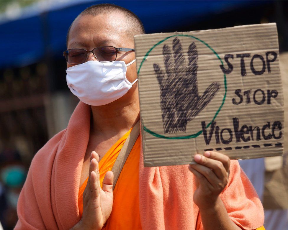 A Buddhist monk of the Dhammakaya sect temple holds a placard as monks confront with Thai policemen outside the temple in Pathum Thani, north of Bangkok, Thailand, Monday, 20 February 2017.
