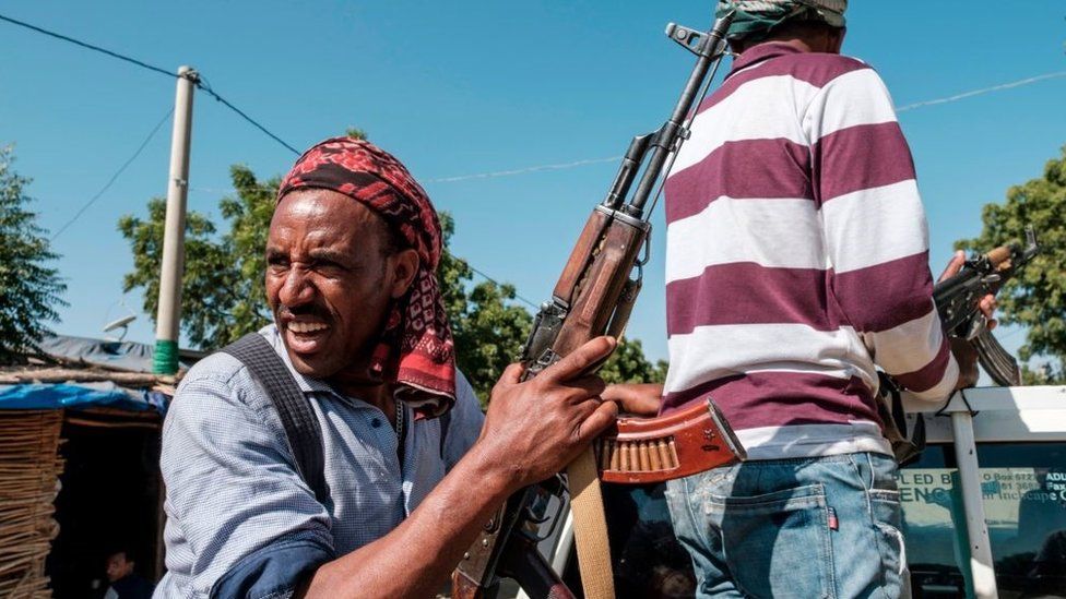 Two members of the Amhara militia ride in the back of a pick up truck, in Mai Kadra, Ethiopia, on November 21, 2020.