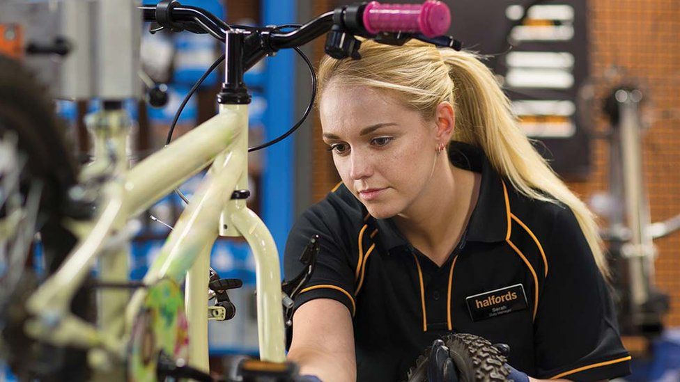 Сотрудник Halfords ремонтирует велосипед