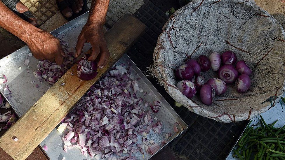 An Indian restaurant worker cuts onions for curries in New Delhi on September 11, 2015.