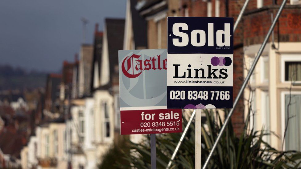 For Sale and Sold signs outside houses in north London