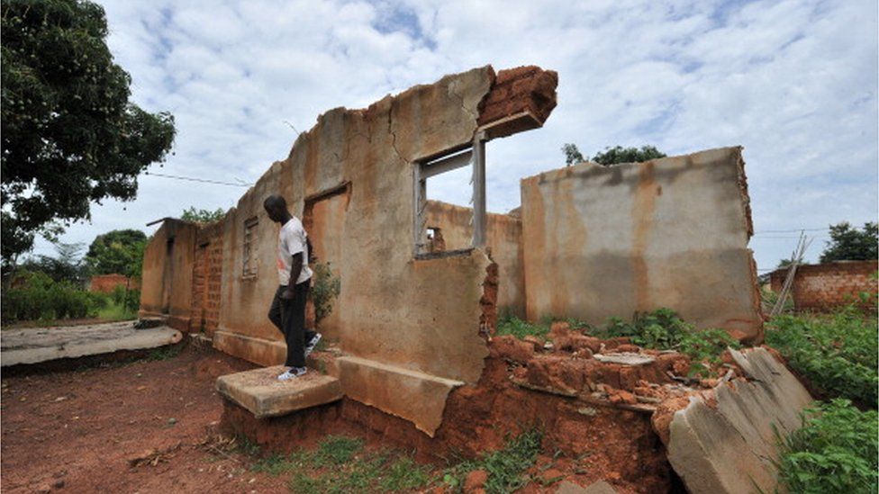 A man walks through a house destroyed during post-electoral violence that occurred in 2011 in the western Ivory coast village of Niambli, near Duekoue on April 21, 2012