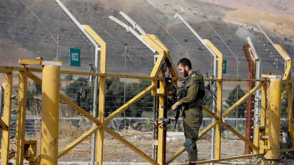 An Israeli soldier closes a border gate on the Israeli side of the border at the Jordan Valley site of Naharayim, also known as Baqura in Jordan, east of the Jordan river on November 10, 2019