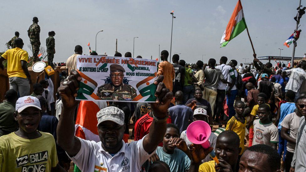 Protesters in Niger waving flags and holding pictures of the