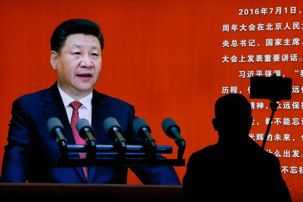 A man takes a selfie near a picture of Chinese President Xi Jinping on display at an exhibition on the Long March at the military museum in Beijing, Monday, 24 October 2016.