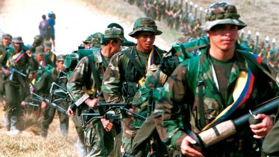 Leftist rebels of the Revolutionary Armed Forces of Colombia (FARC) patrol by a roadway near to San Vicente de Caguan, Caqueta province, Colombia, January 9. 1999