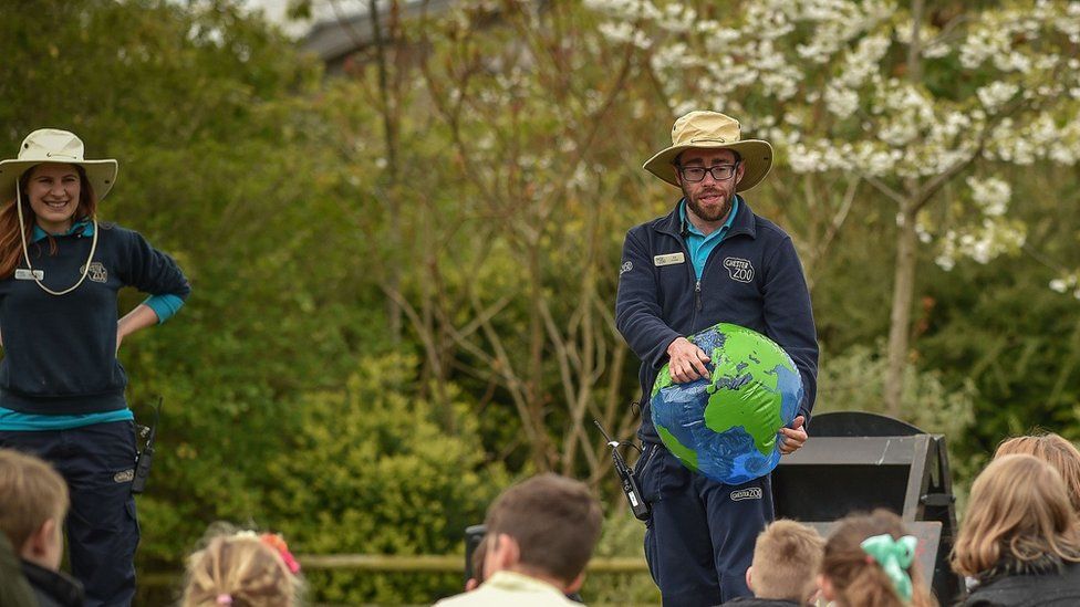 Chester Zoo worker holding inflatable globe teaching children