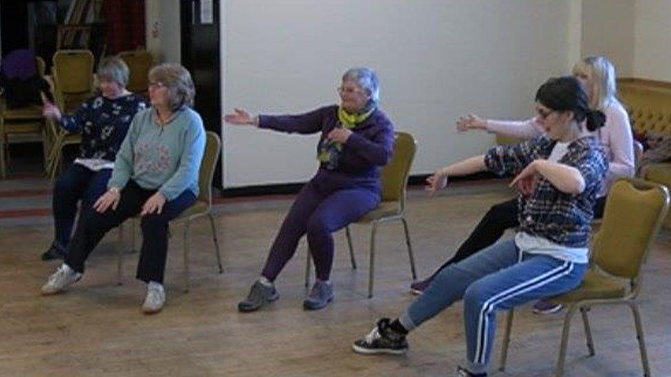 Women in chairs doing dance exercises
