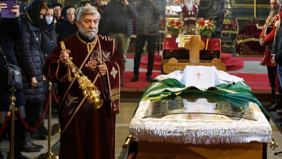 A priest delivers a service to the late Serbian Patriarch Irinej in Belgrade, Serbia, 21 November 2020.