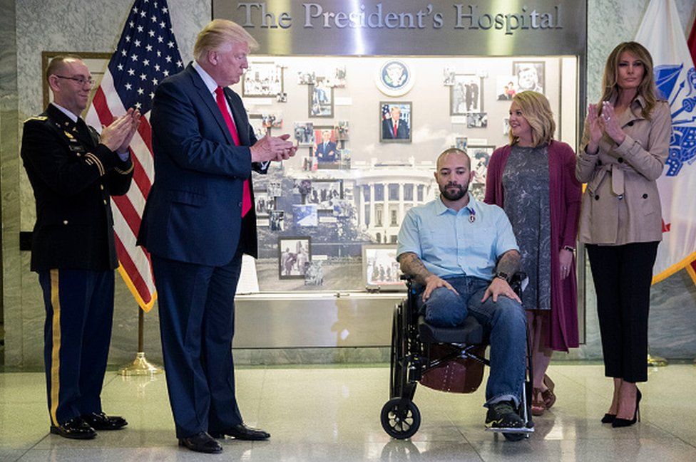Trump presents a medal to US Sergeant First Class Alvaro Barrientos, who was injured in Afghanistan