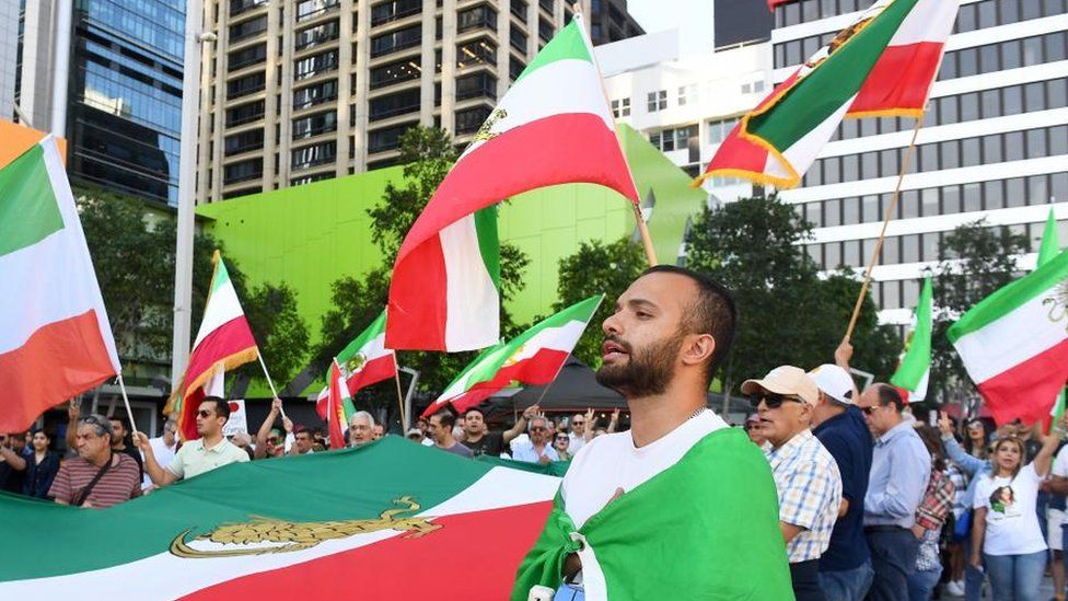 People hold Iranian flags during a rally in Brisbane, Australia