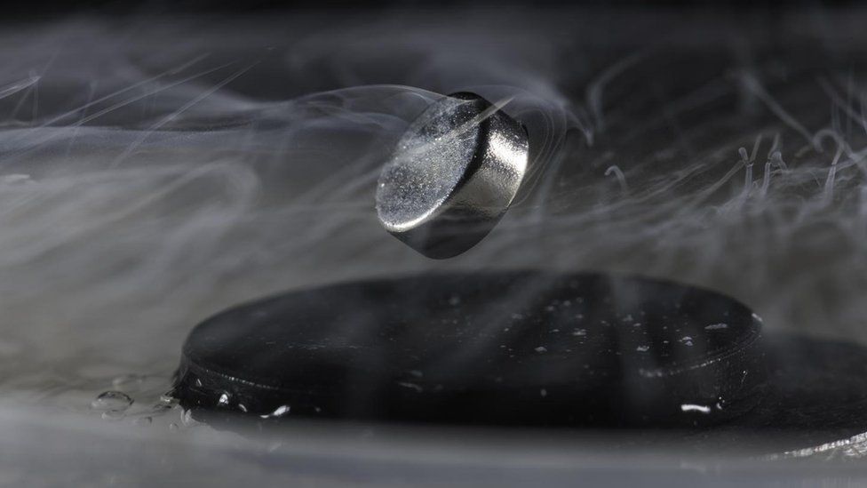 A magnet floats above a superconductor cooled with liquid nitrogen