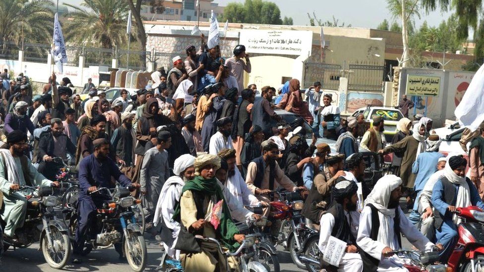 Taliban supporters celebrate along a street in Kandahar on August 31, 2021