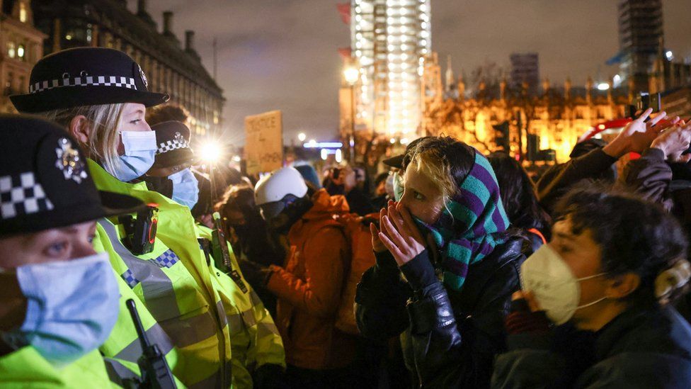 People face off police officers during a protest at Parliament Square, following the kidnap and murder of Sarah Everard