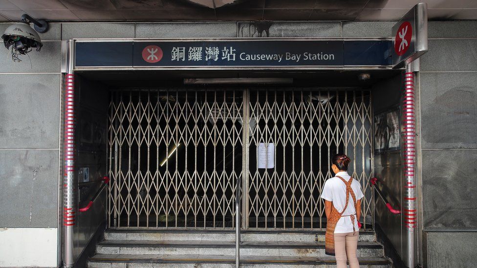 A woman stands in front of a closed entrance gate to the Causeway Bay MTR train station in Hong Kong, China, 05 October 2019