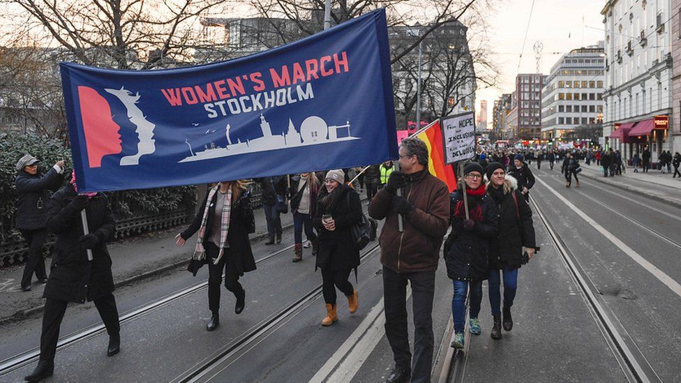 Protesters carrying banners and placards take part in a Women's March in Stockholm, Sweden, on 21 January