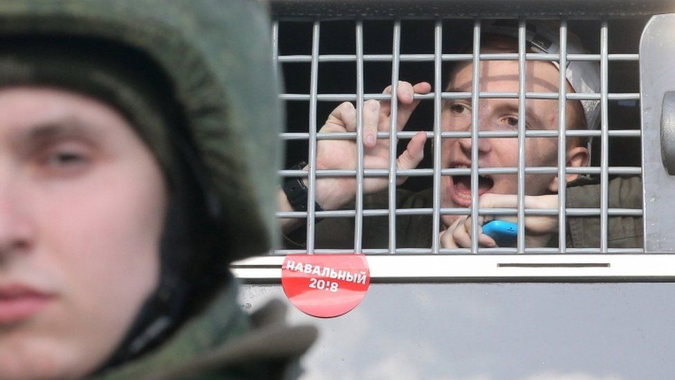 A protester shouts from a police bus after detention on Sunday in Moscow