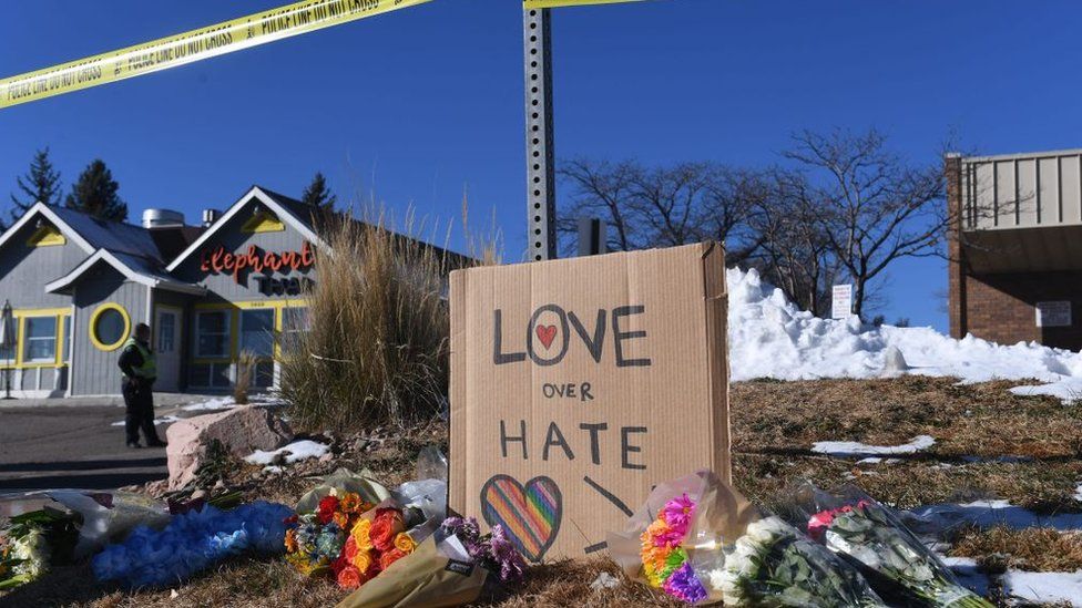 Flowers and a sign saying "love over hate"