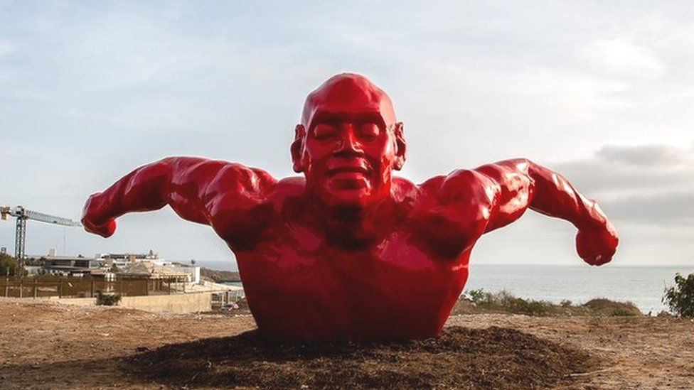 Diadji Diop's sculpture of a red swimmer.