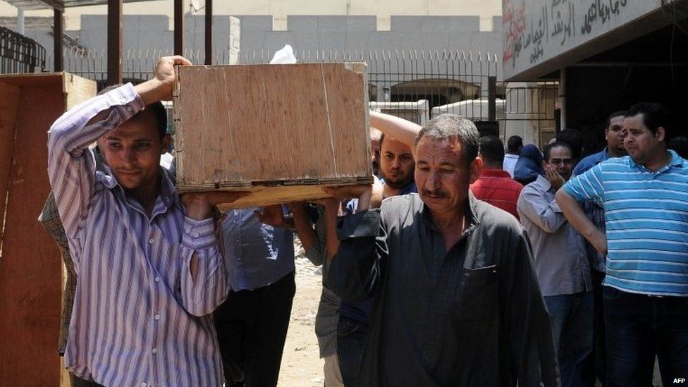 Men carry the coffin of an Islamist detainee who died when tear gas was fired into a transport vehicle (19 August 2013)