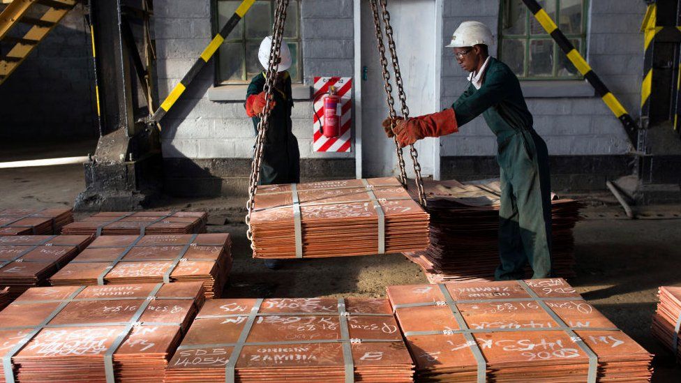 Workers move batches of copper sheets in Mufulira, Zambia