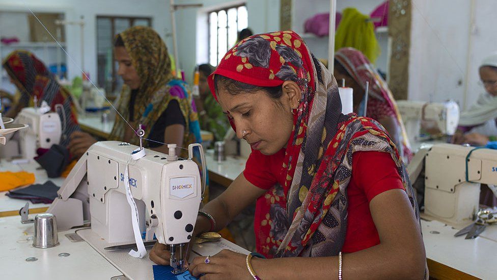 Indian woman sewing textiles at Dastkar women's craft co-operative, the Ranthambore Artisan Project, in Rajasthan, Northern India