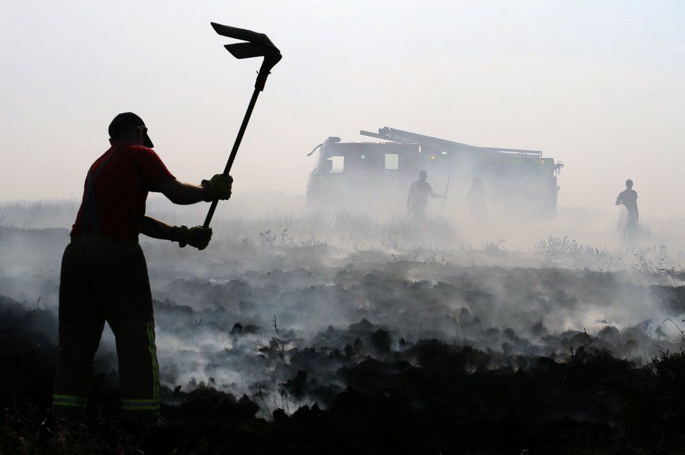 Firefighters beat out wildfires on Winter Hill near Rivington in Lancashire, north west England on 1 July 2018.