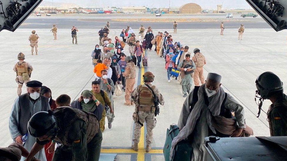 Afghans and Spanish citizens residing in Afghanistan board a military plane as part of their evacuation