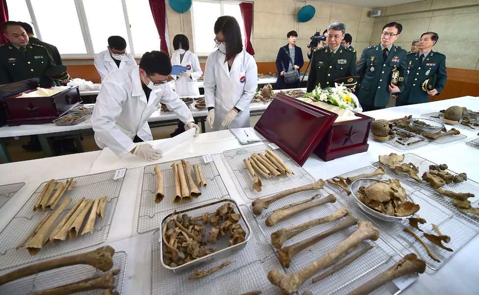 South Korea's Agency for KIA (Killed in Action) Recovery and Identification members (in white) prepare the remains of Chinese war dead in 2015