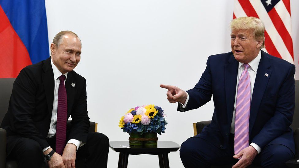 US President Donald Trump (R) attends a meeting with Russia's President Vladimir Putin
