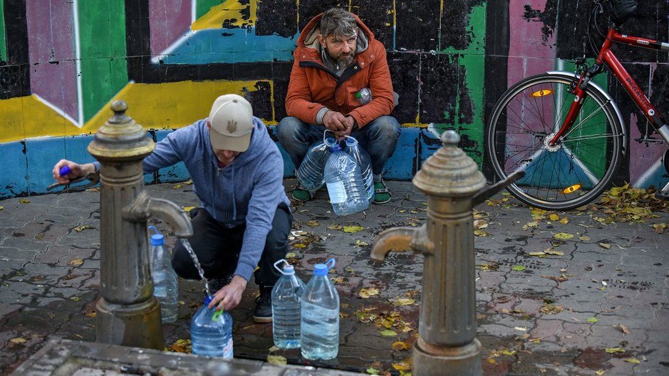 Los residentes de Kiev llenan botellas de agua después de que sus hogares se quedaron sin agua debido a los ataques con misiles rusos