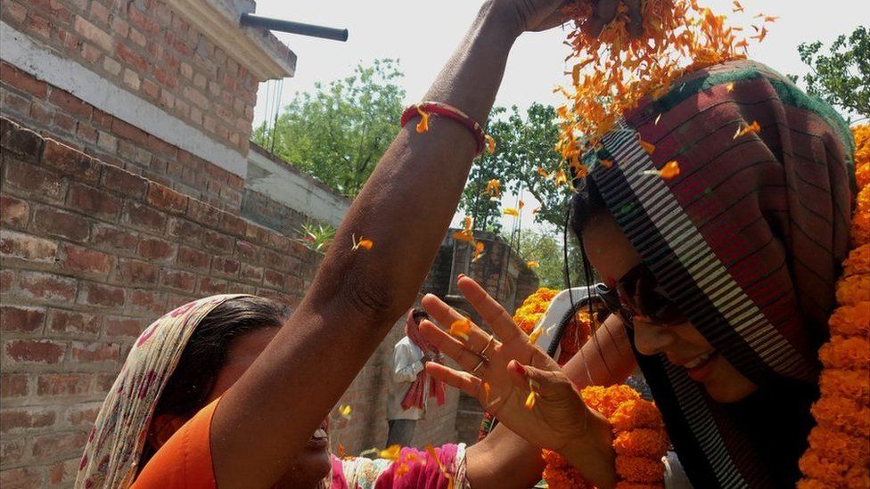 A supporter throws marigold petals at Mahua Moitra