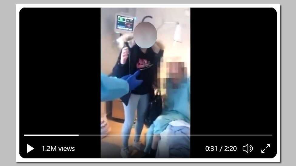 На видео, снятом внутри больницы, виден пациент в постели и несколько медперсоналов, обслуживающих его