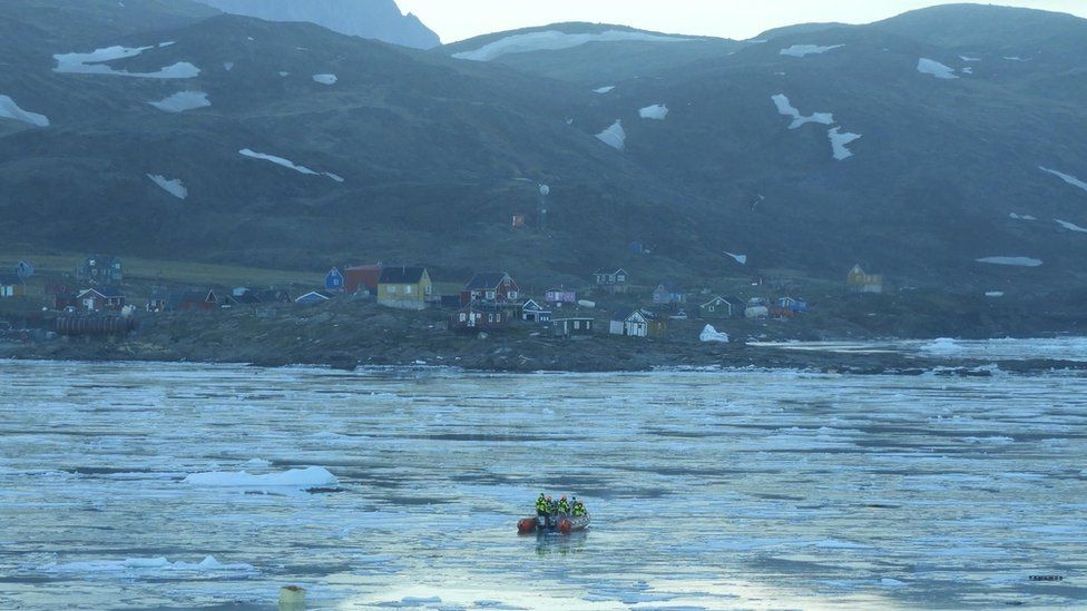 Rescuers use a life raft to search for the missing after a tsunami hit the village of Nuugaatsiaq, northwestern Greenland