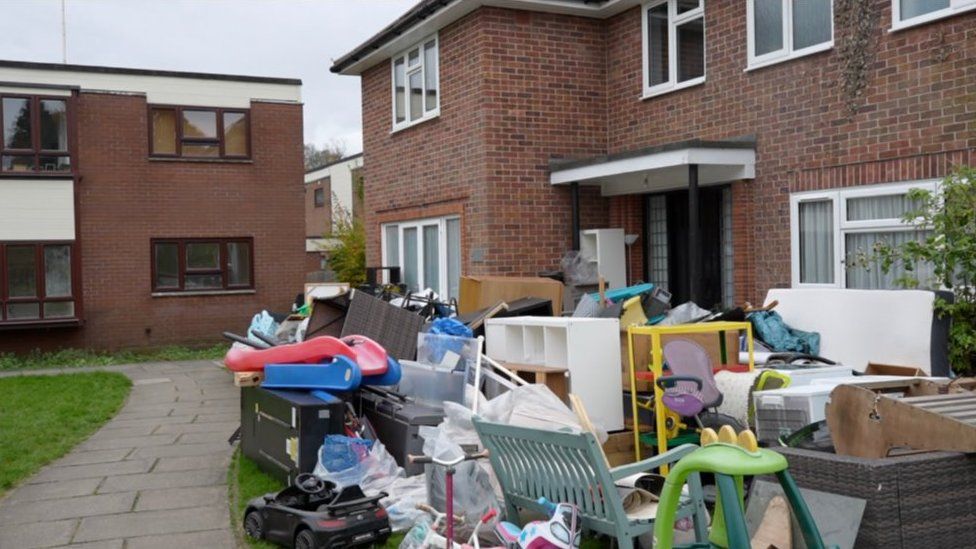 Contents piled up outside house after flooding
