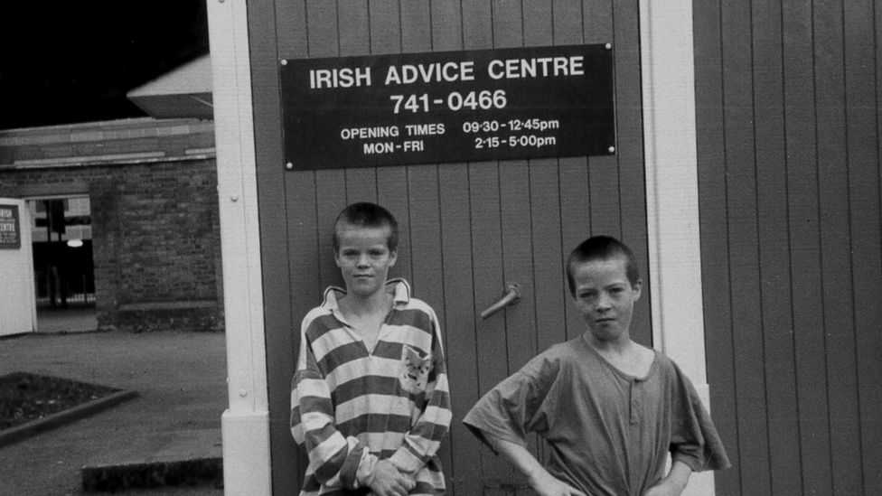 Two boys by an Irish advice centre sign