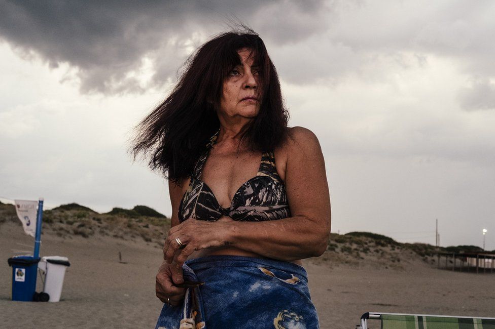 Woman under grey clouds on a beach